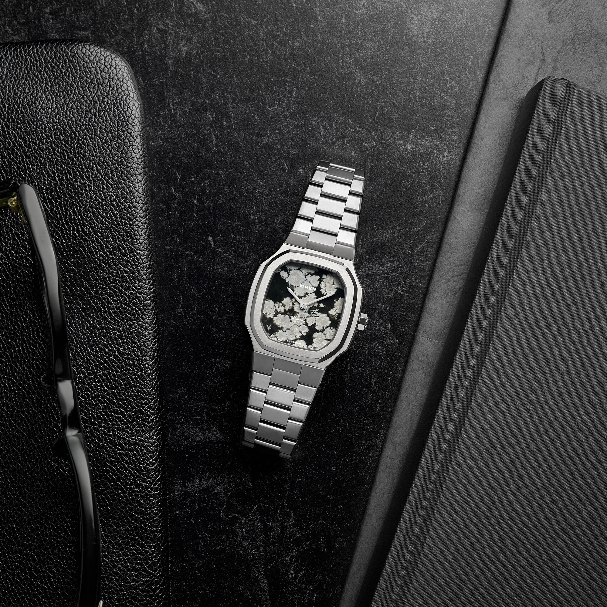 MAEN Manhattan 37 Ultra Thin Snowflake Obsidian in a dark still-life setting